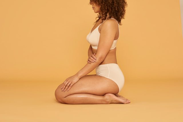 woman sitting in underwear on studio background