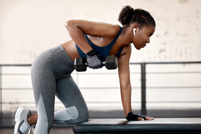 Shot of a sporty young woman exercising with a dumbbell in a gym