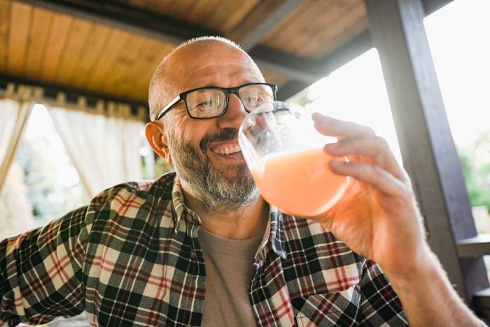 man drinking pink alcoholic beverage