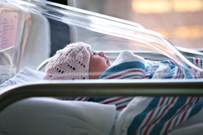 Newborn baby in hospital bassinet.