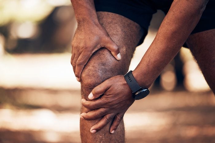 Knee pain, senior hands and injury in nature after accident, workout or training. Sports, athlete health and elderly black man with fibromyalgia, inflammation or tendinitis, arthritis or painful legs