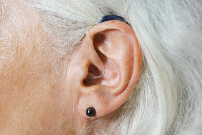 Close-up of woman with gray hair wearing hearing aid