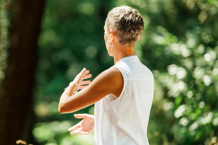 Woman practicing tai chi outside in the forest