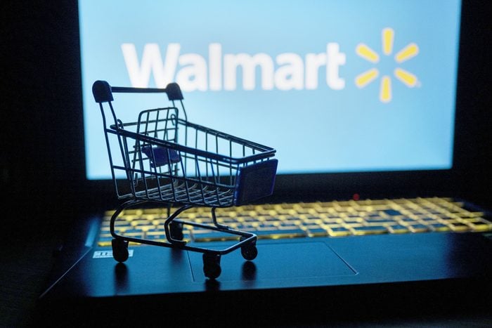 mini shopping cart on a laptop that has the walmart logo in the background