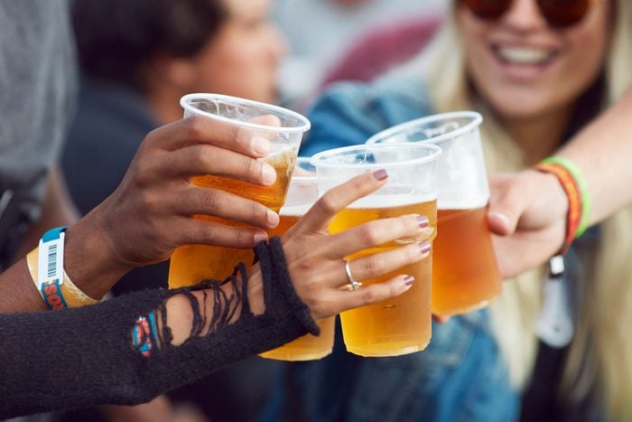 Close-up of hands toasting in beer