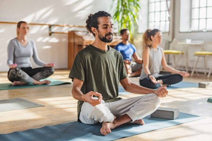 Adult Arab Male With A Ponytail Meditating In A Yoga Class