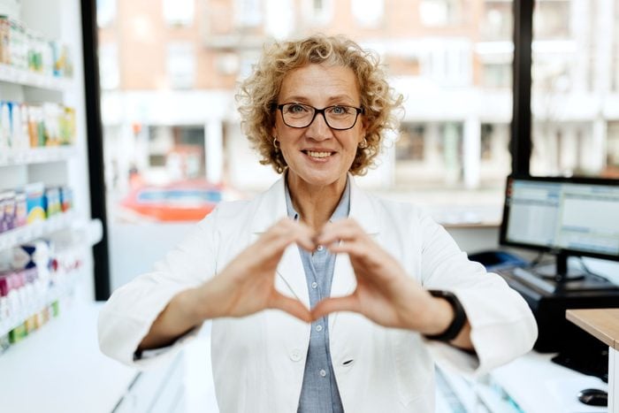 Female pharmacist or doctor holding heart shape using left and right hand