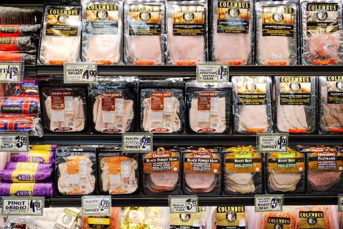 Variety of packaged sliced ham on shelves in a Trader Joe's grocery store