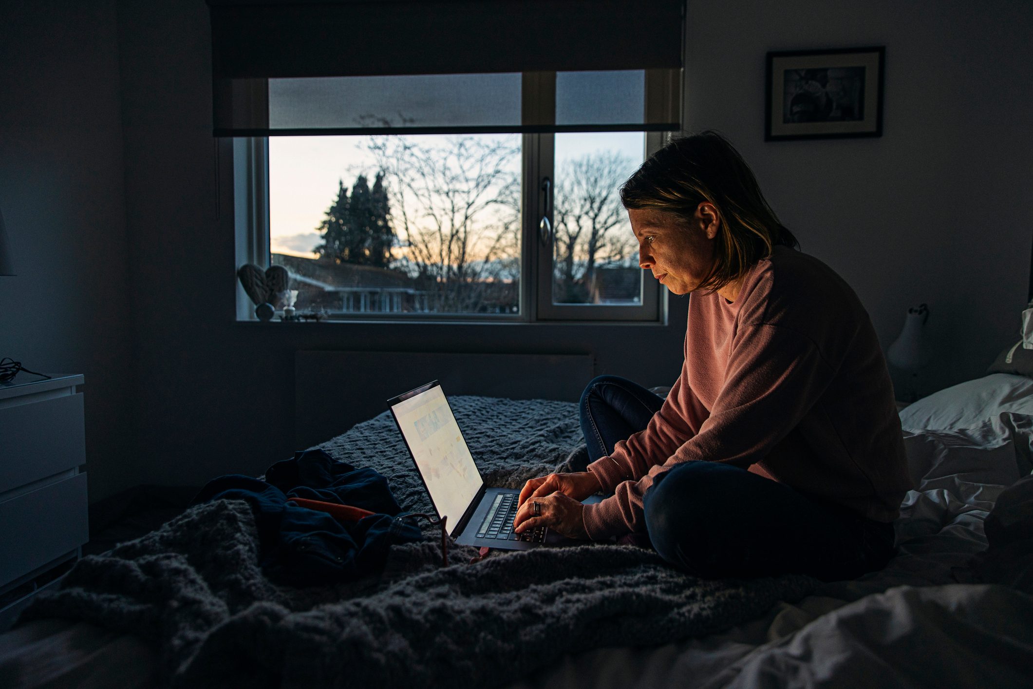 Woman working from home on her laptop in the evening.